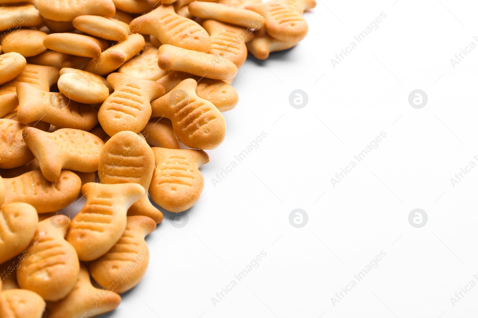 Photo of Delicious crispy goldfish crackers on white background, closeup