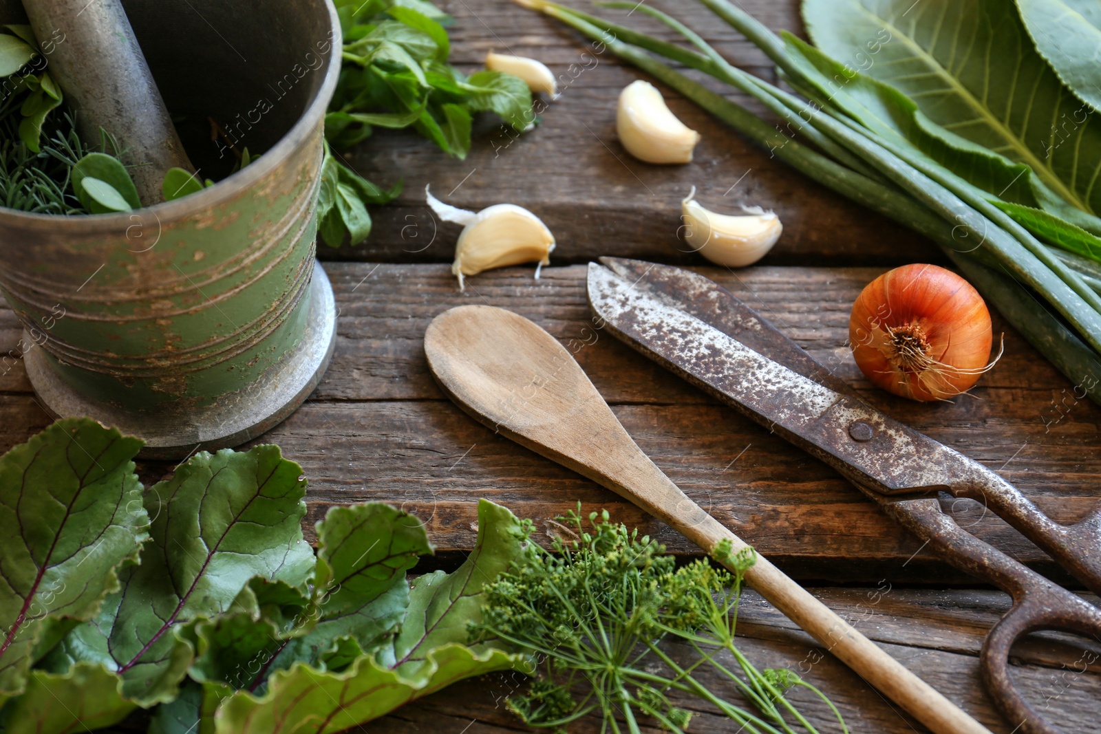 Photo of Different herbs, rusty scissors and spoon on wooden table