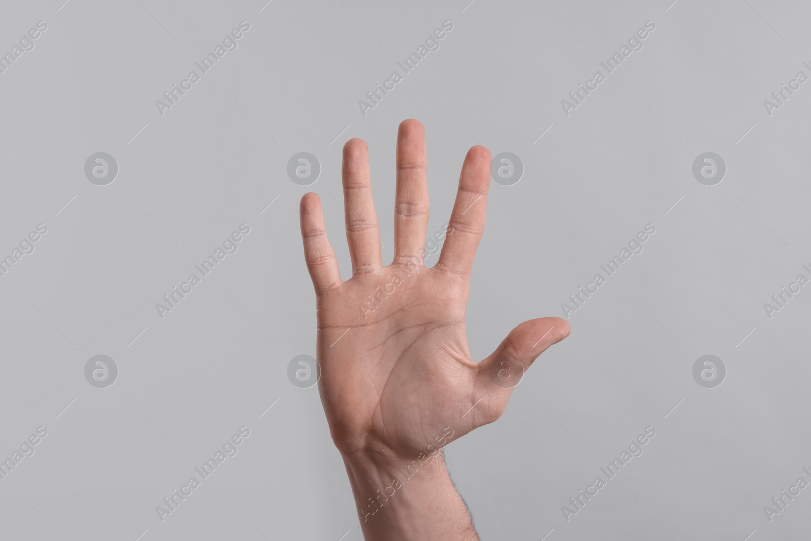 Photo of Man giving high five on grey background, closeup of hand