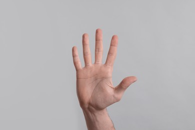 Photo of Man giving high five on grey background, closeup of hand