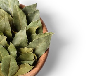 Aromatic bay leaves in wooden bowl on white background, closeup