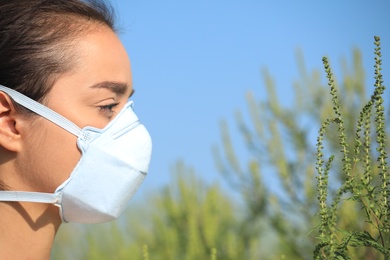 Young woman suffering from ragweed allergy outdoors, closeup