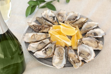 Photo of Fresh oysters with cut juicy lemon served on table