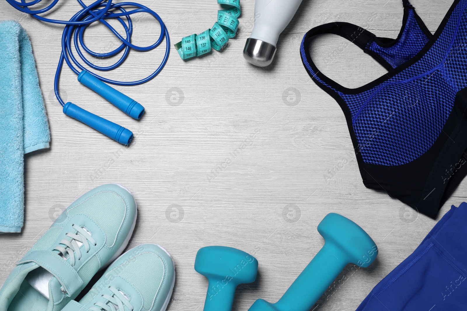 Photo of Clothes and sports equipment on white wooden table, flat lay with space for text. Personal training