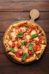 Photo of Delicious Margherita pizza on wooden table, top view