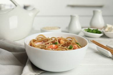 Tasty buckwheat noodles with shrimps served on white wooden table