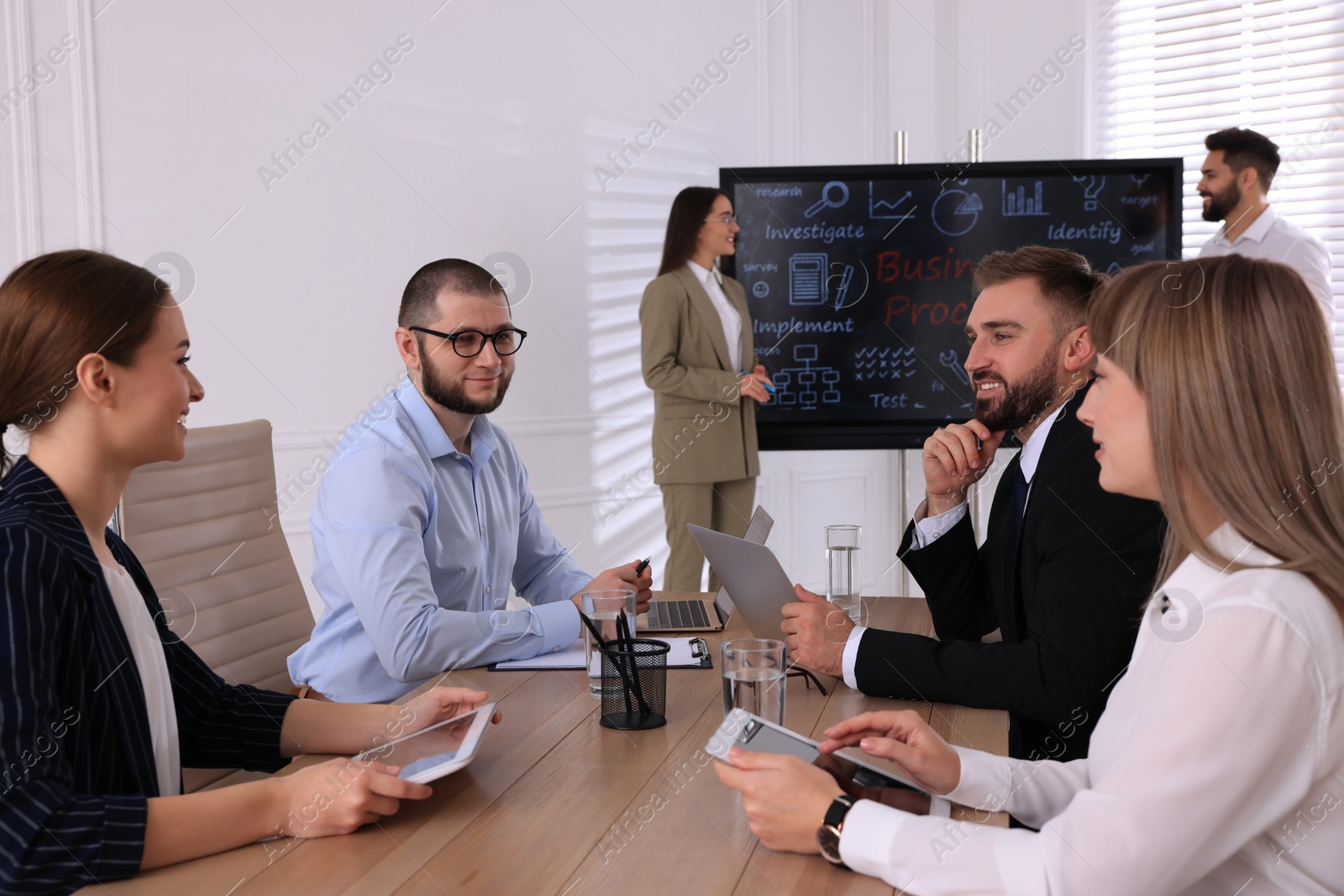 Photo of Business training. People in meeting room with interactive board