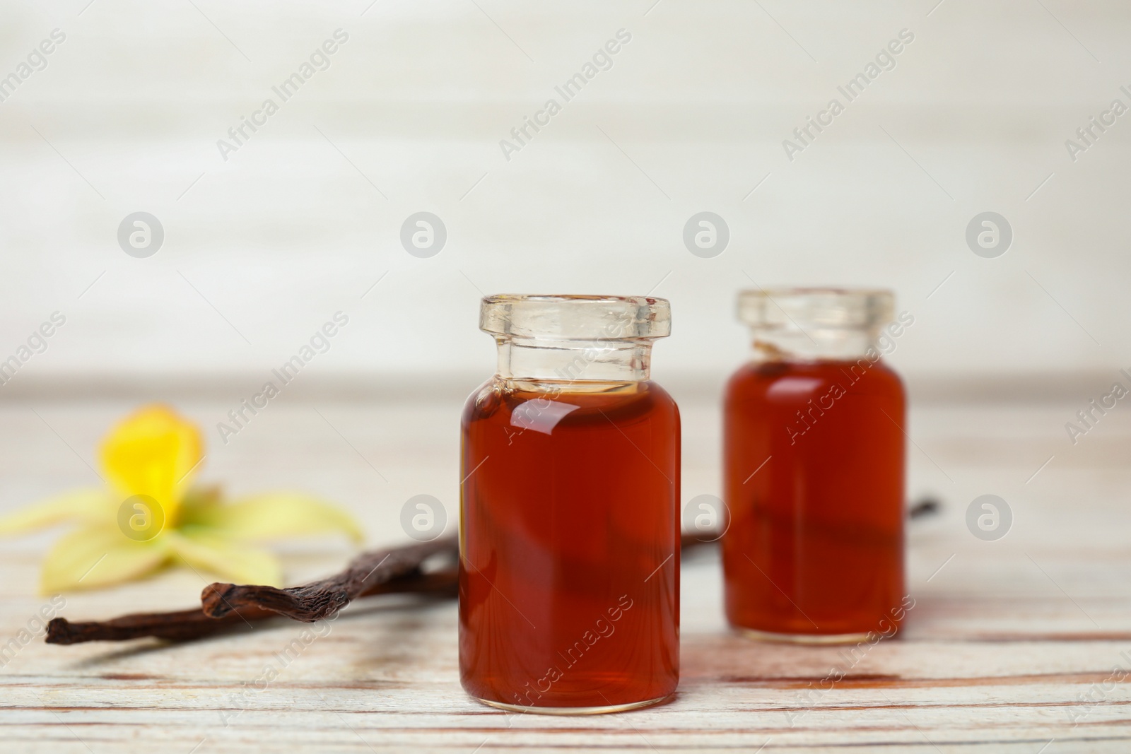 Photo of Aromatic homemade vanilla extract on white wooden table