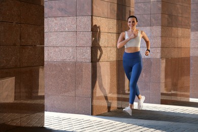 Photo of Beautiful woman in stylish sportswear running outdoors