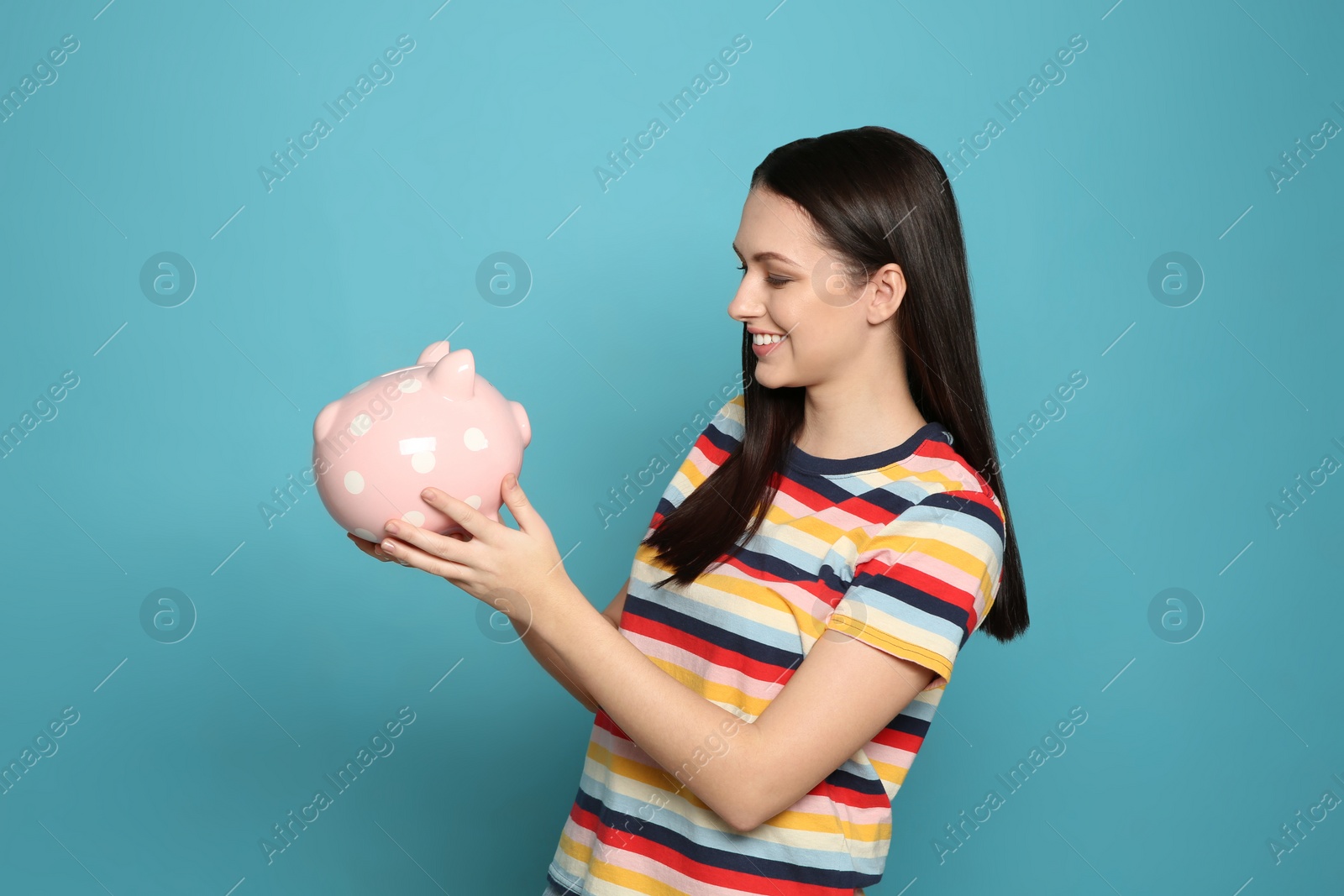 Photo of Young woman with piggy bank on color background