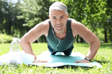 Photo of Handsome mature man doing exercise in park. Healthy lifestyle