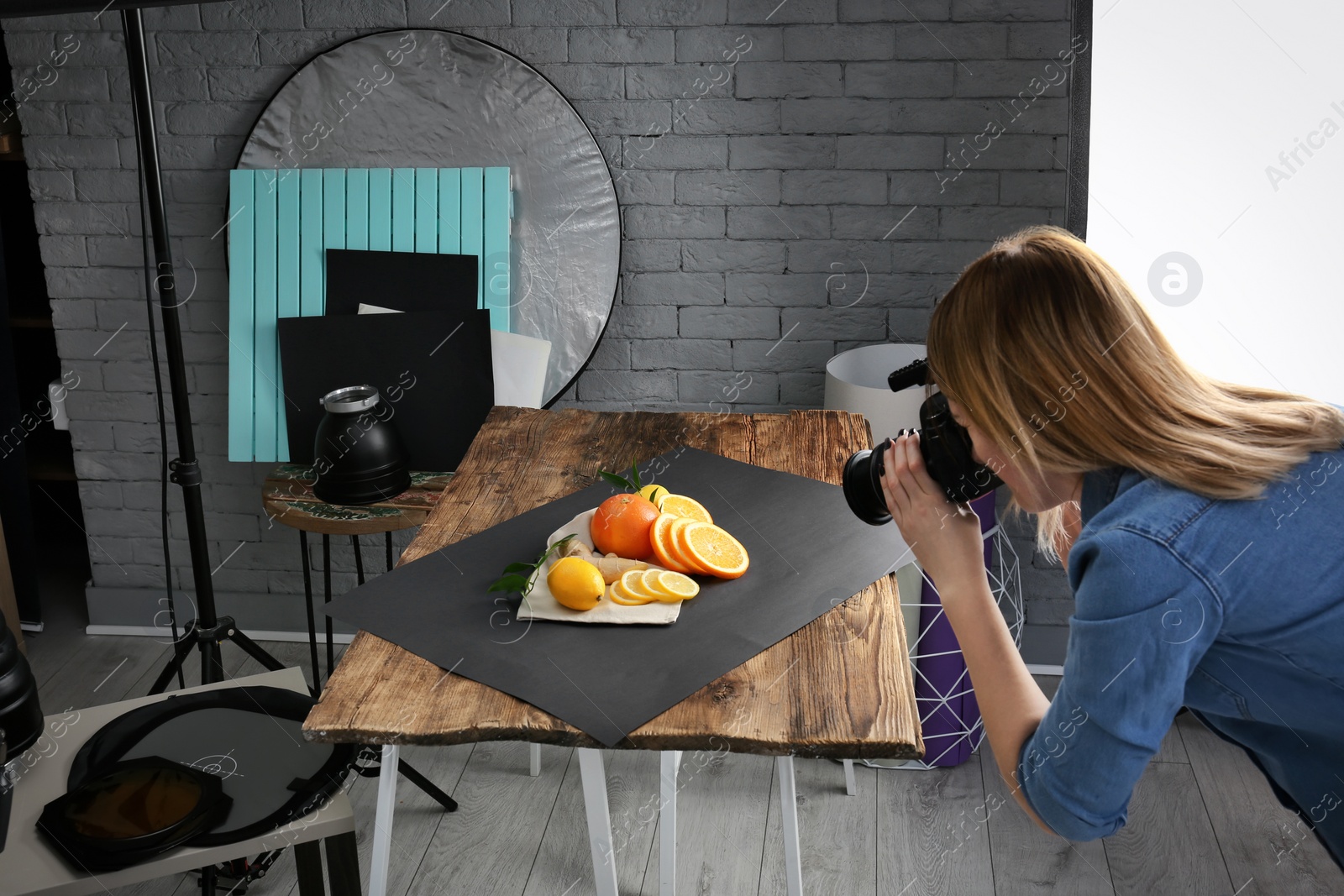 Photo of Woman taking photo of food with professional camera in studio