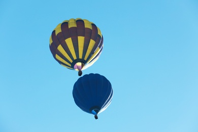 Photo of Colorful hot air balloons flying in blue sky. Space for text
