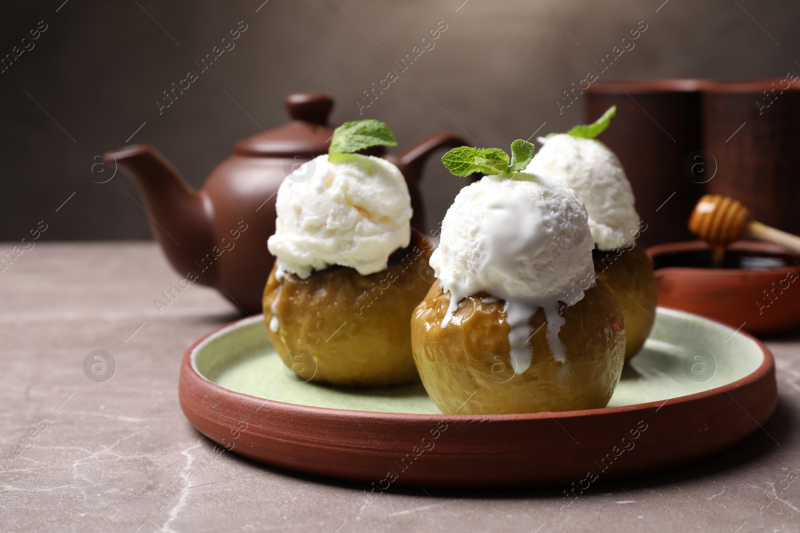 Photo of Delicious baked apples with ice cream and mint served on grey table, space for text