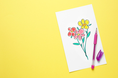 Photo of Top view of greeting card with drawn flowers and pen on yellow background, space for text. Happy Mother's day