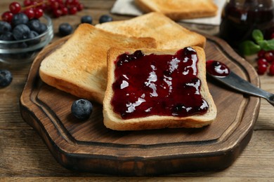 Delicious toasts with jam served on wooden table, closeup