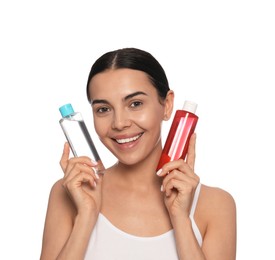 Photo of Young woman with bottles of micellar water on white background