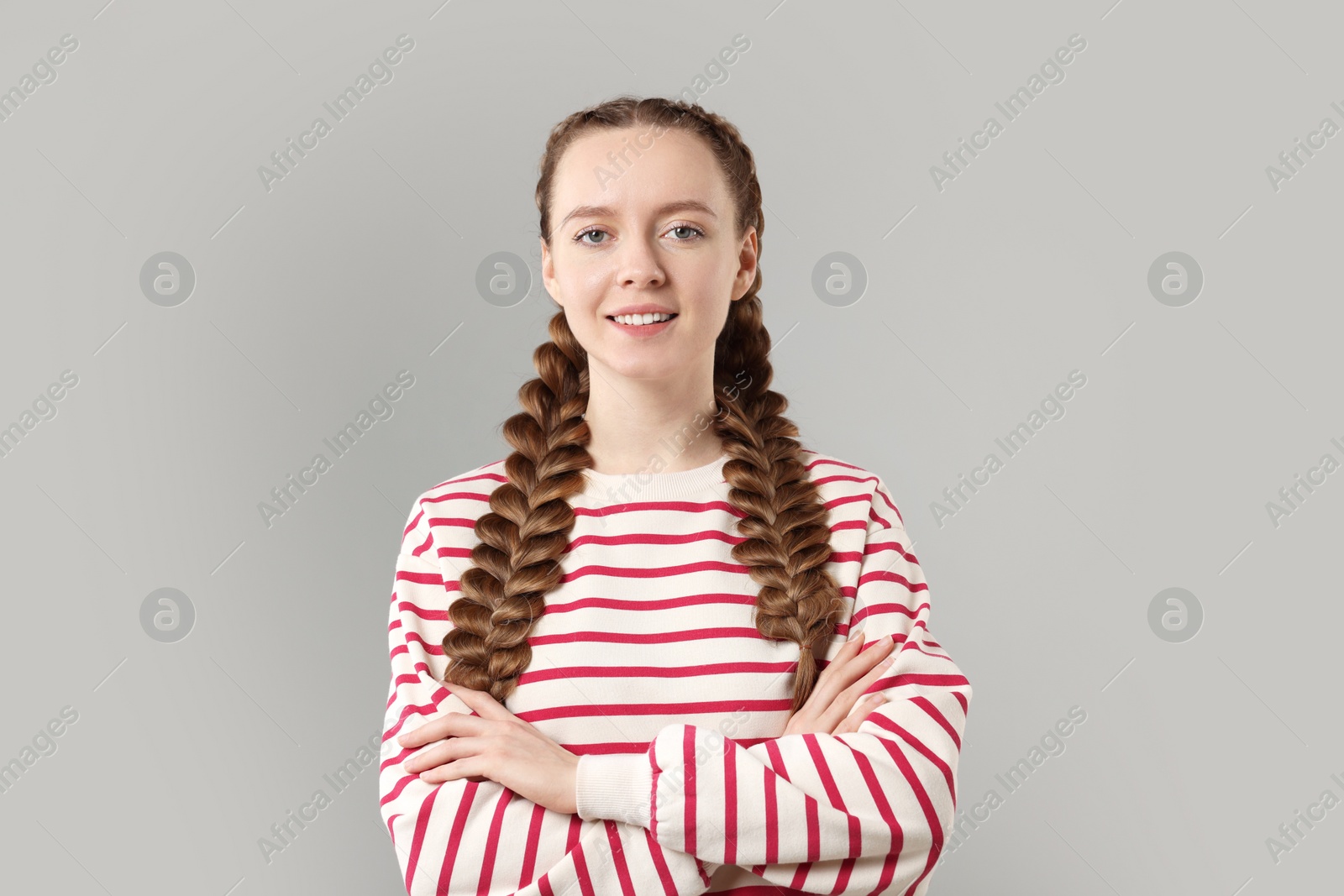 Photo of Woman with braided hair on grey background