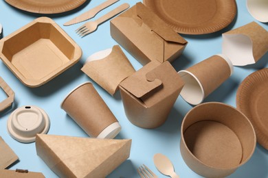 Eco friendly food packaging. Paper containers and tableware on light blue background