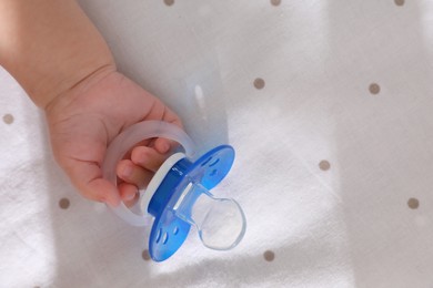 Little baby with pacifier in bed, closeup