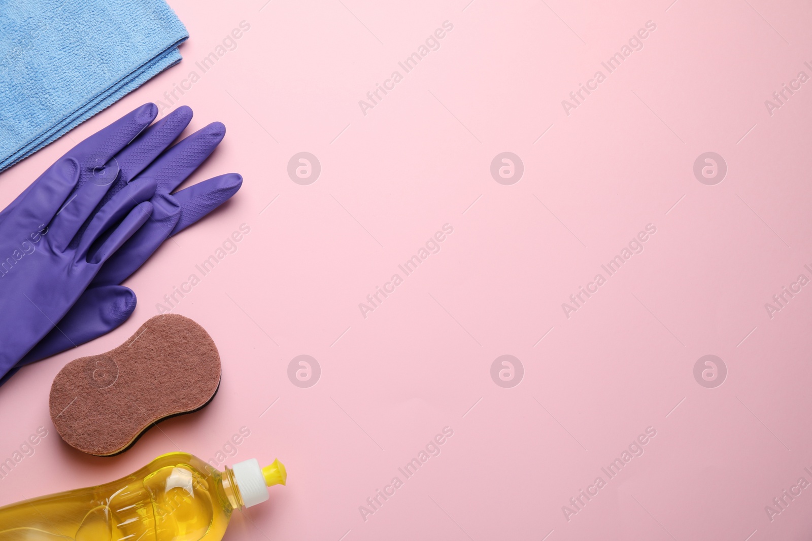 Photo of Flat lay composition with sponge and other cleaning supplies on pink background. Space for text