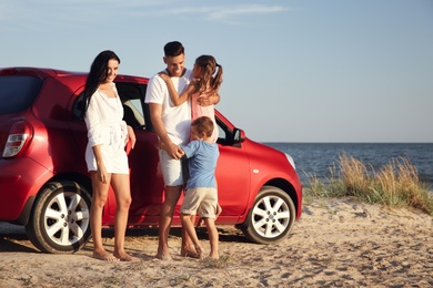 Photo of Happy family near car on sandy beach, space for text. Summer trip
