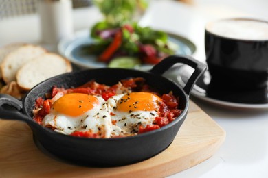 Photo of Tasty Shakshouka served on white table, closeup. Traditional Arabic dish