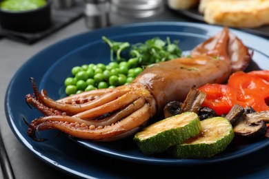 Delicious grilled squid served on black table, closeup