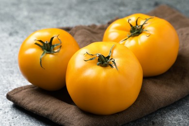 Fresh ripe yellow tomatoes on grey table, closeup