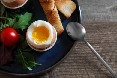 Photo of Delicious breakfast with soft boiled eggs served on wooden table, closeup