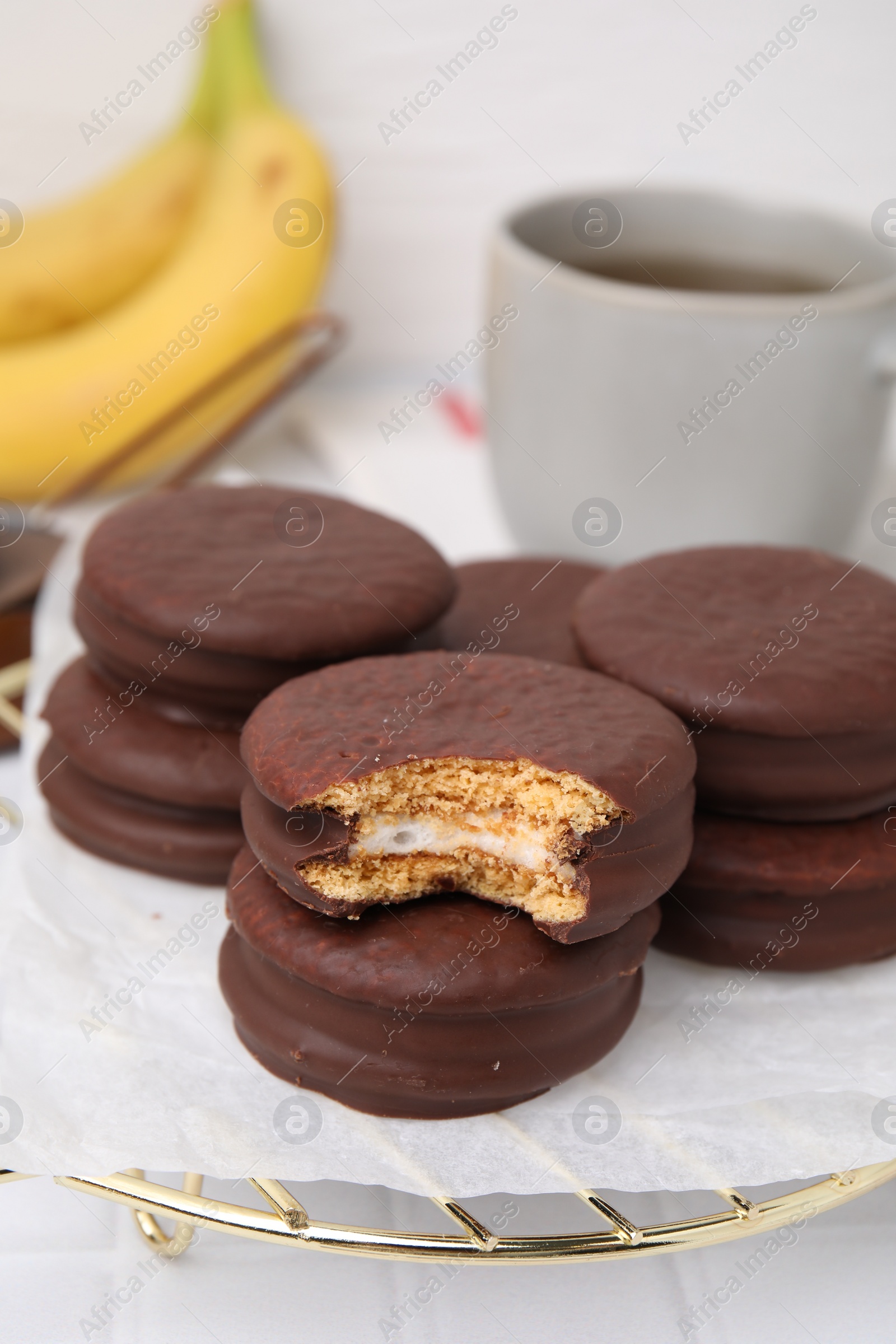 Photo of Tasty banana choco pies on white table, closeup