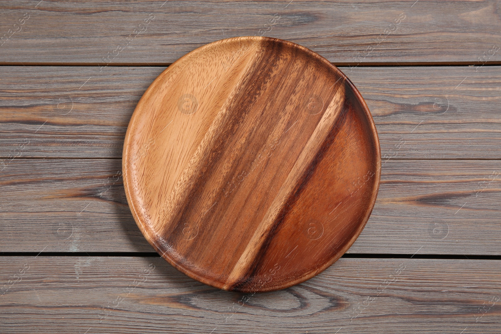 Photo of One plate on grey wooden table, top view