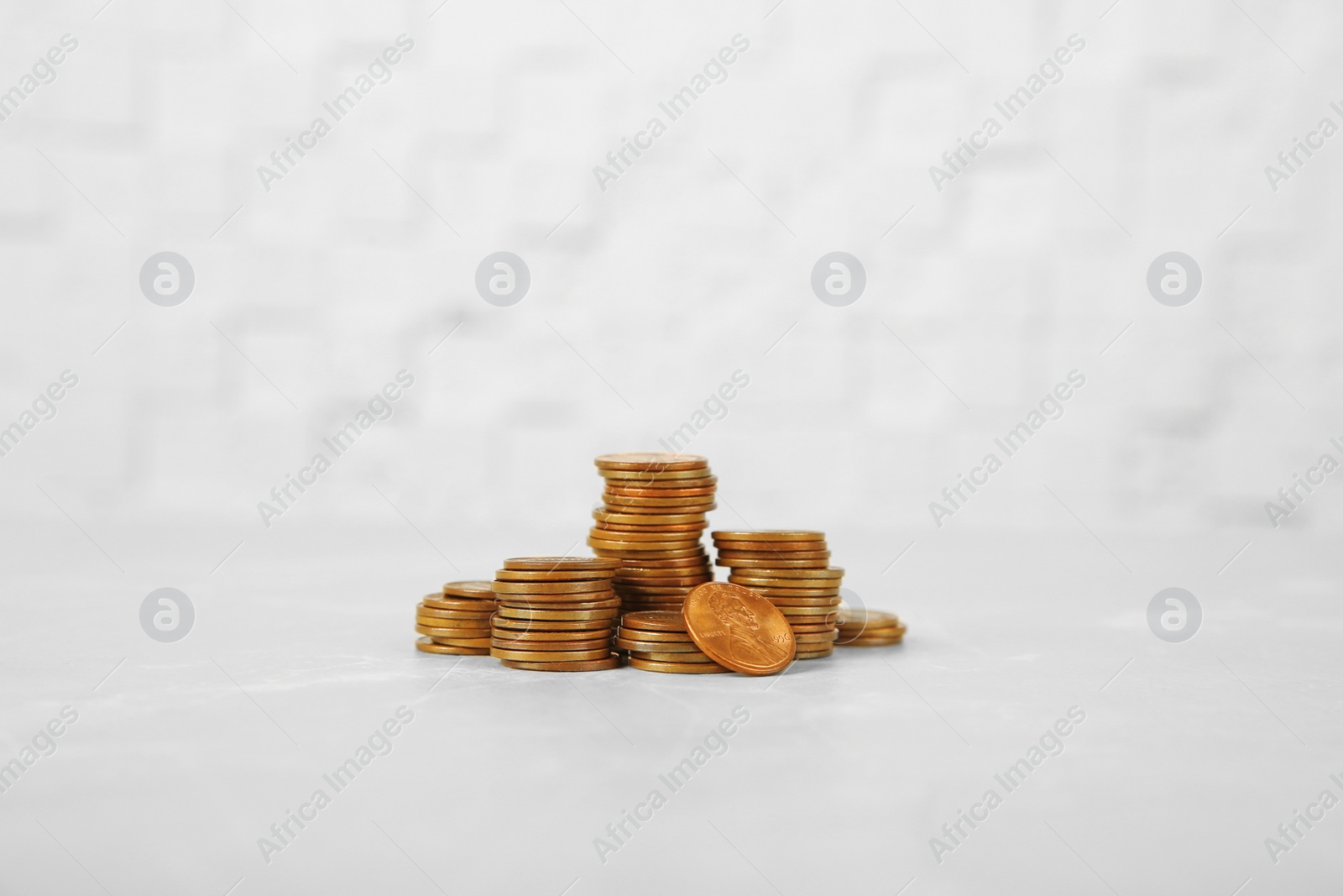 Photo of Many stacks of coins on table against light background