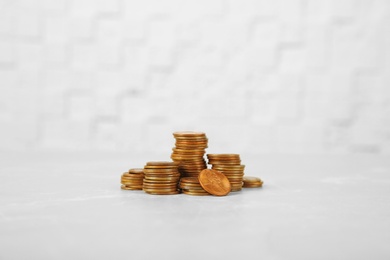 Photo of Many stacks of coins on table against light background