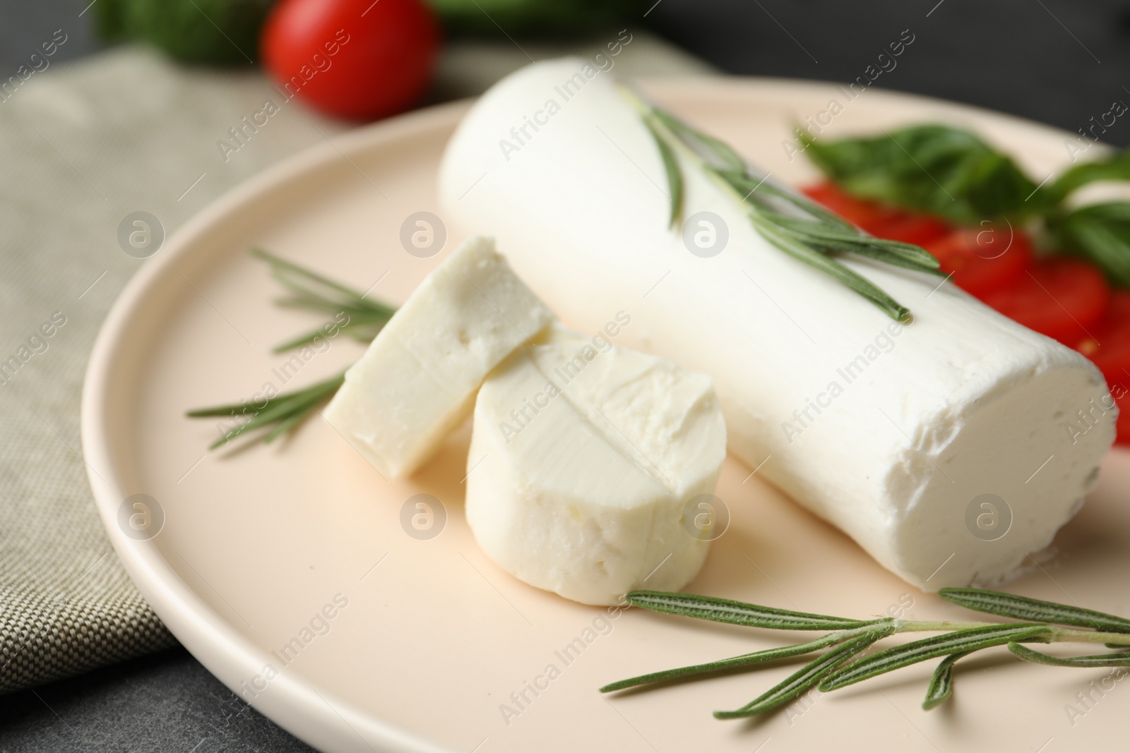 Photo of Delicious goat cheese with rosemary on plate, closeup