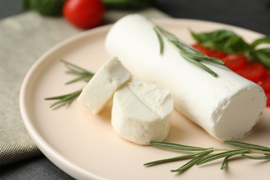 Photo of Delicious goat cheese with rosemary on plate, closeup