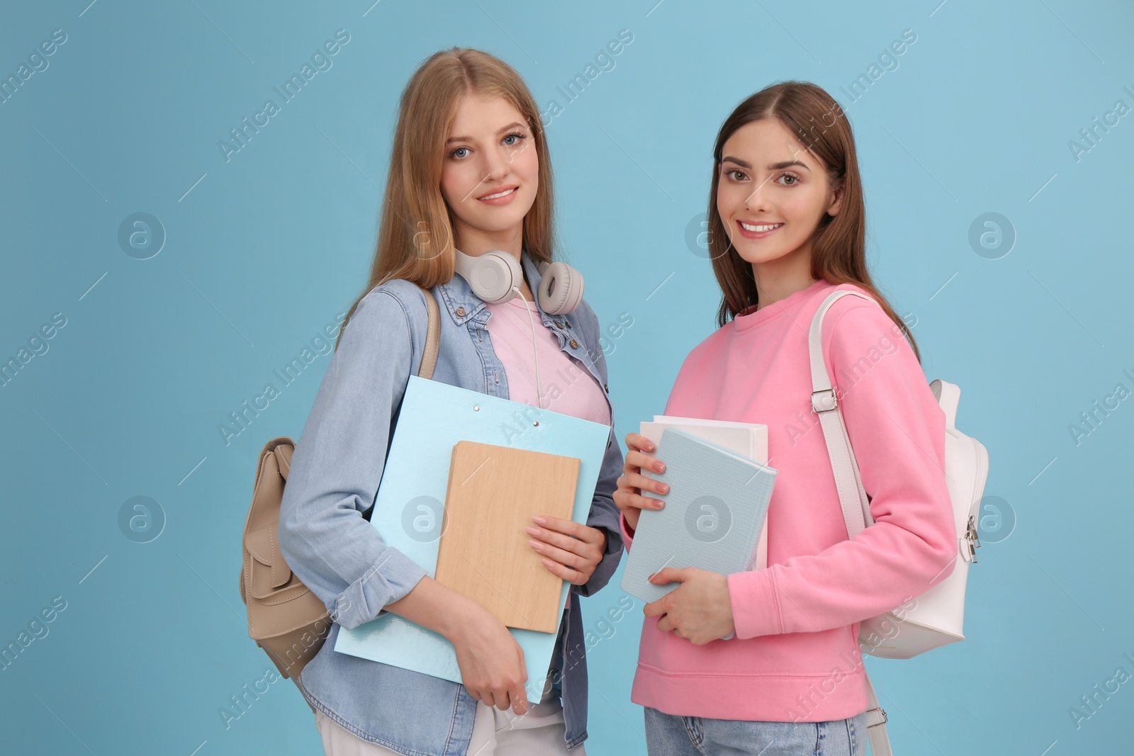 Photo of Teenage students with stationery and backpacks on turquoise background