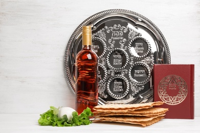Photo of Symbolic Passover (Pesach) items on table against wooden background, space for text