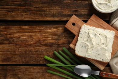 Delicious sandwich with cream cheese and chives on wooden table, flat lay. Space for text