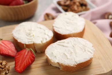 Photo of Delicious bruschettas with ricotta cheese, strawberries and walnuts on table, closeup