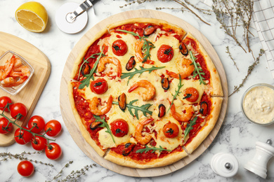 Photo of Delicious seafood pizza on white marble table, flat lay