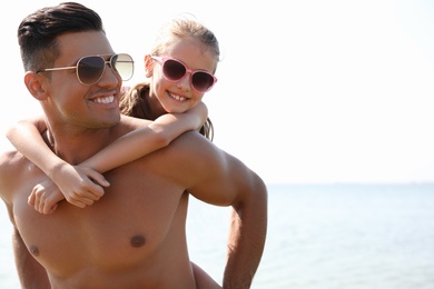 Father playing with daughter at beach. Family vacation