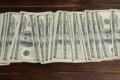 Photo of Money exchange. Dollar banknotes on wooden background, top view