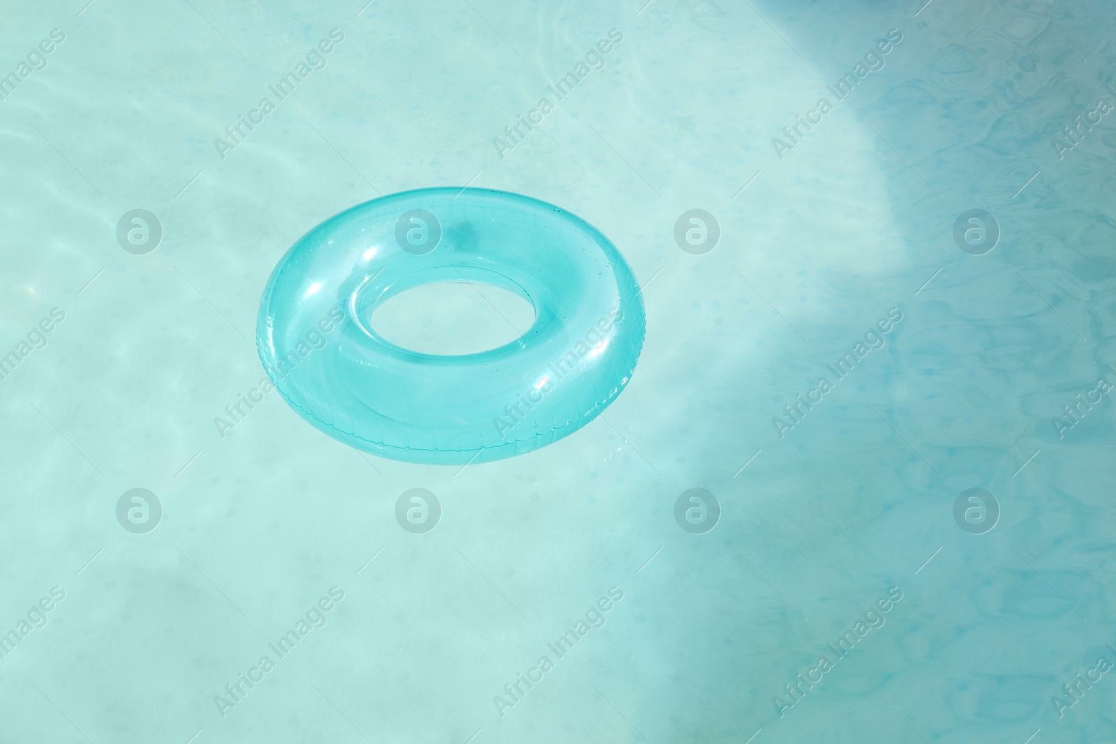 Photo of Inflatable ring floating on water in above ground swimming pool outdoors