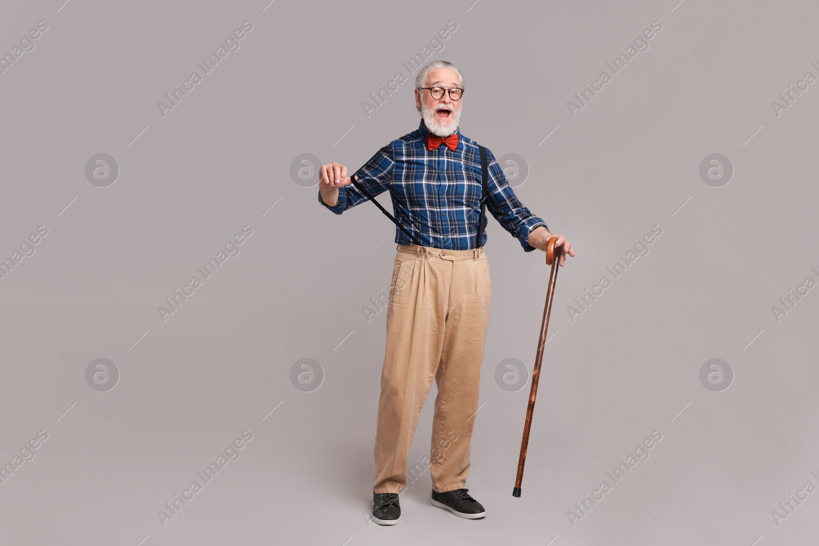 Photo of Emotional senior man with walking cane on gray background