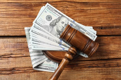 Judge's gavel and money on wooden table, top view