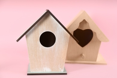 Beautiful wooden bird houses on pink background