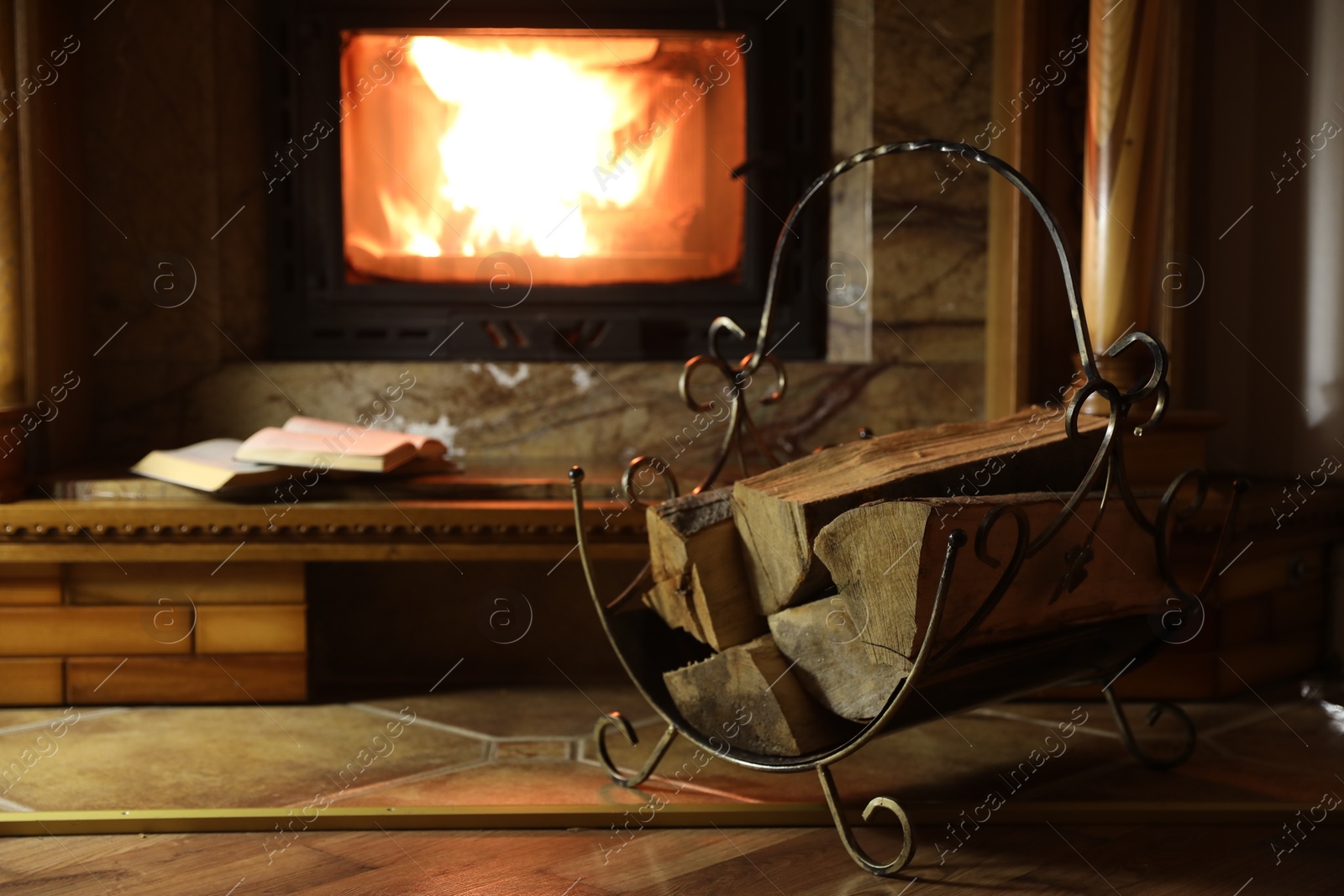 Photo of Books and firewood near fireplace at home