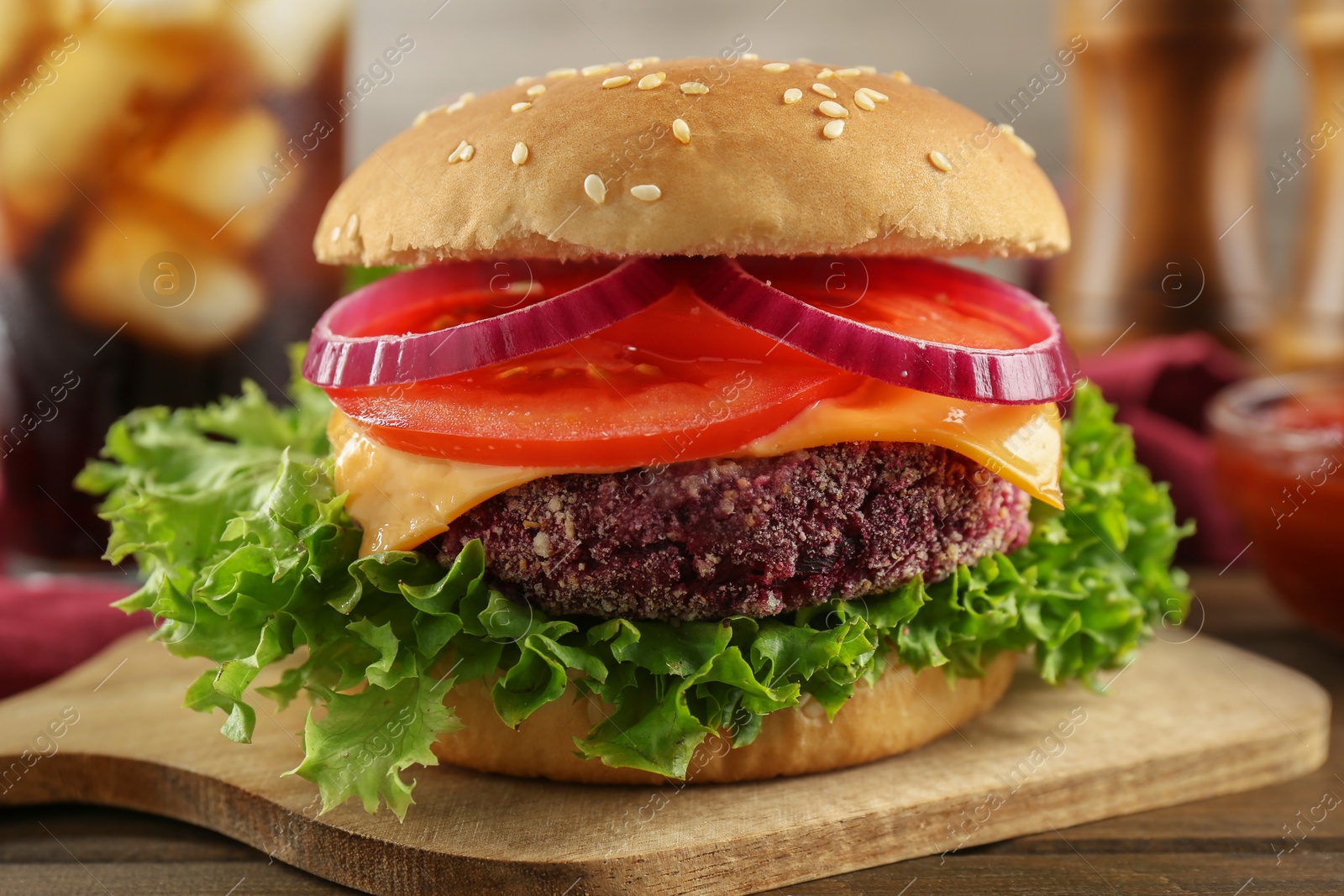 Photo of Tasty vegetarian burger with beet patty on wooden table, closeup