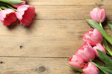 Happy Mother's Day. Beautiful pink tulips on wooden table, flat lay. Space for text